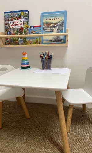 Spielecke mit Kindertisch und Bilderbüchern